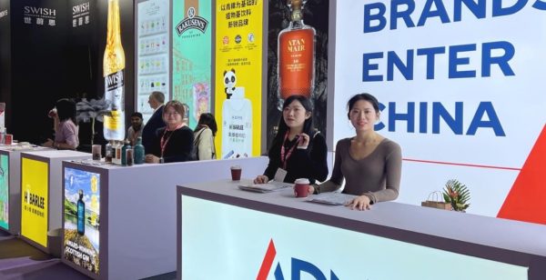 ADN Partnership booth at a trade show in China, with staff and promotional displays